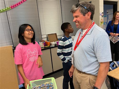 BOE member Scott Newberry speaking with student in her classroom
